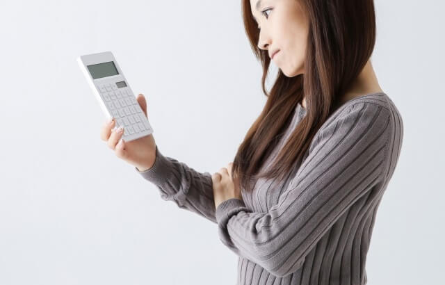 電卓を見て考える女性